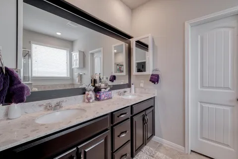 a bathroom with a double vanity sink and mirror