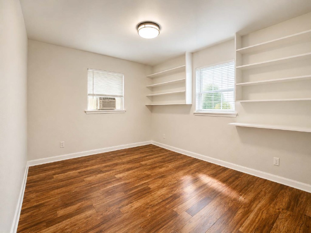 610 Gunter Street Austin, TX 78702 - Photo 8 of 16 Ample built-in shelving provides storage and display space, complementing rich wood flooring.