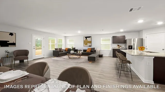 a living room with furniture a large window and wooden floor