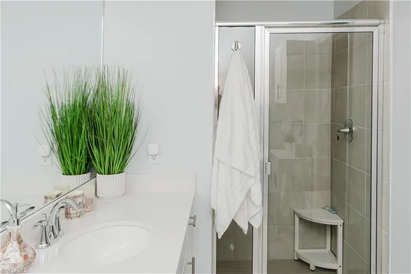 a bathroom with a sink a mirror and shower