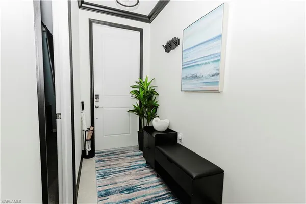 a view of a hallway with wooden floor and a potted plant