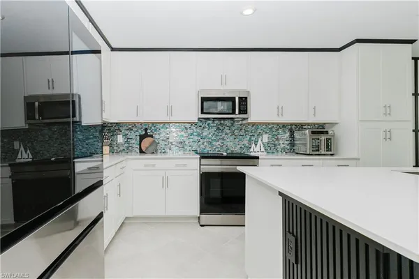 a kitchen with stainless steel appliances a stove microwave and sink