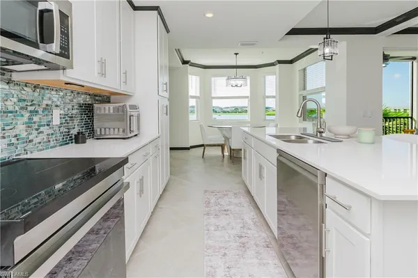 a kitchen with stainless steel appliances granite countertop a stove a sink and a microwave