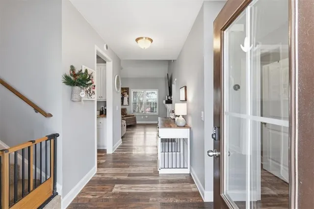 a view of a hallway with wooden floor and a living room