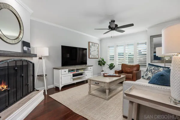 a living room with furniture a flat screen tv and kitchen view