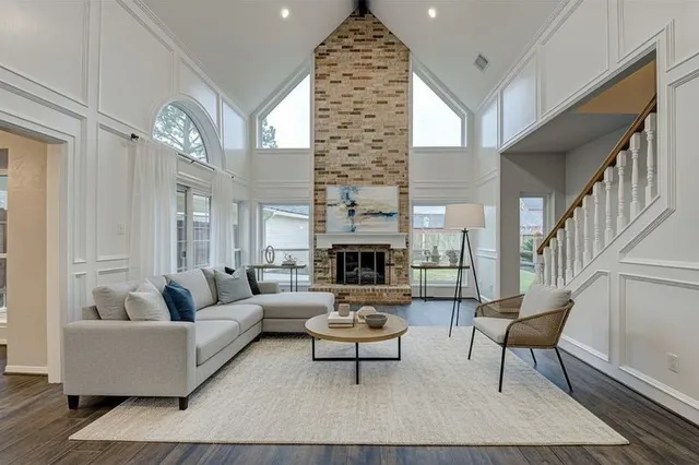 a view of a livingroom with wooden floor a fireplace and windows