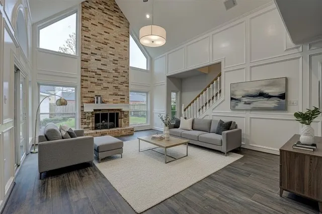 an empty room with wooden floor fireplace and windows