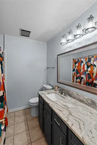 a bathroom with a granite countertop sink a toilet and a mirror