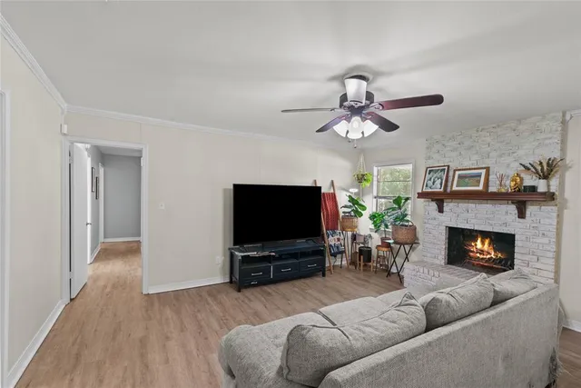 a living room with furniture a flat screen tv and a fireplace