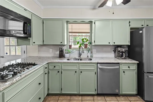 a kitchen with stainless steel appliances a sink stove and cabinets