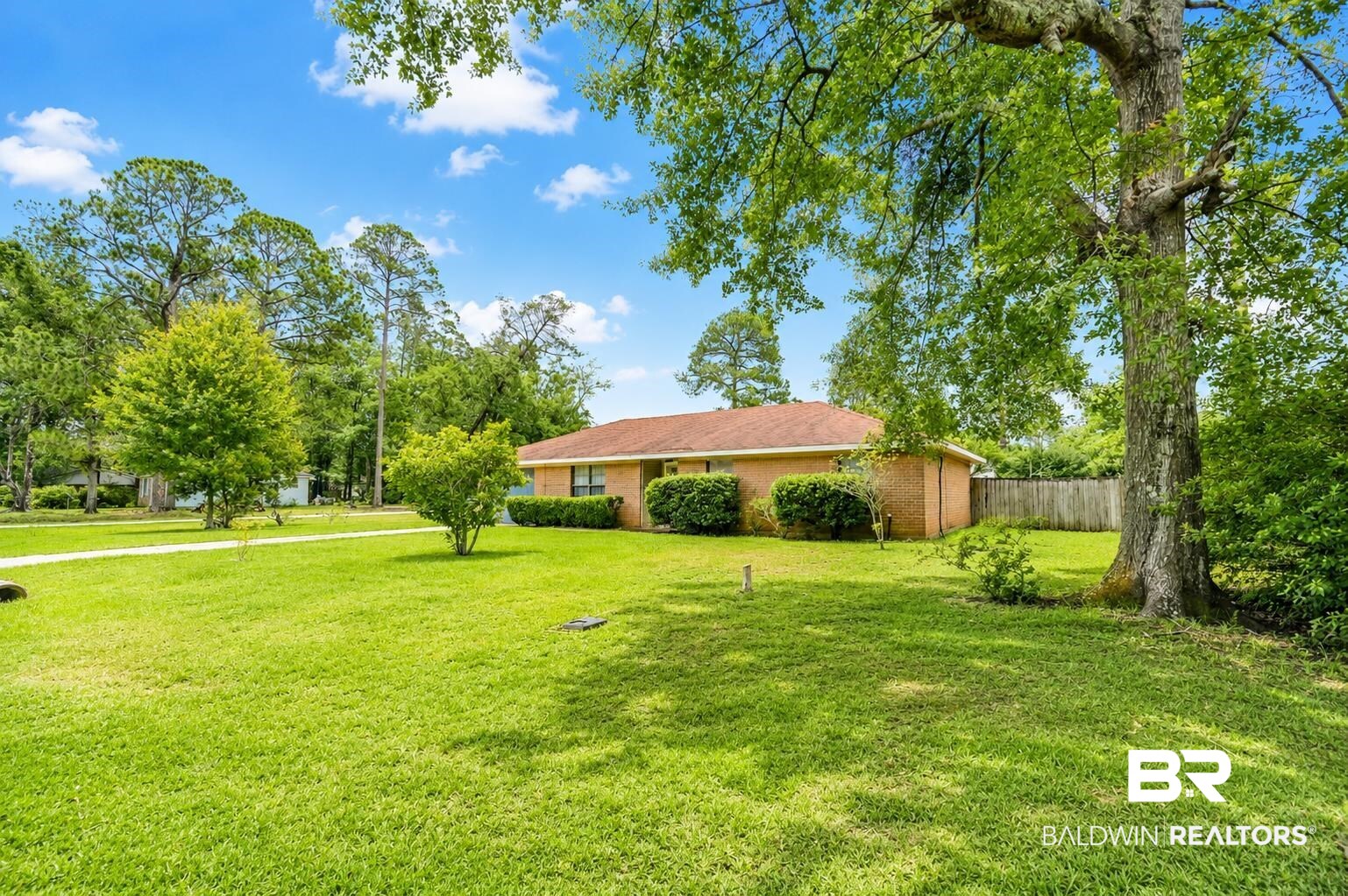 614 East Gate Circle Foley, AL 36535 - Photo 2 of 31 Expansive front yard featuring a manicured lawn, mature trees, and established shrubbery
