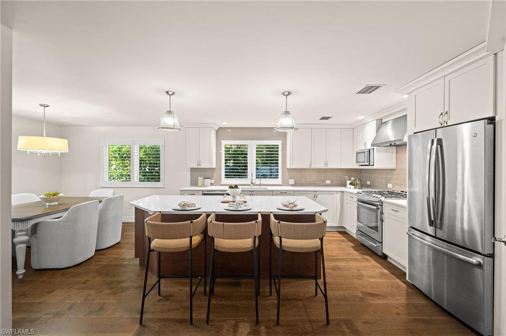 2499 10th Street North Naples, FL 34103 - Photo 12 of 33 a kitchen with stainless steel appliances a dining table and chairs