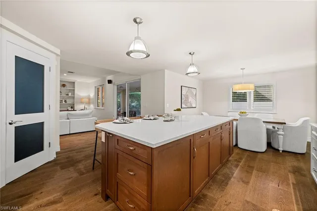 a large white kitchen with kitchen island a stove a sink a center island and furniture