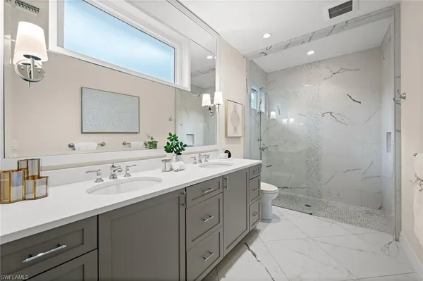 a bathroom with a double vanity sink mirror and shower