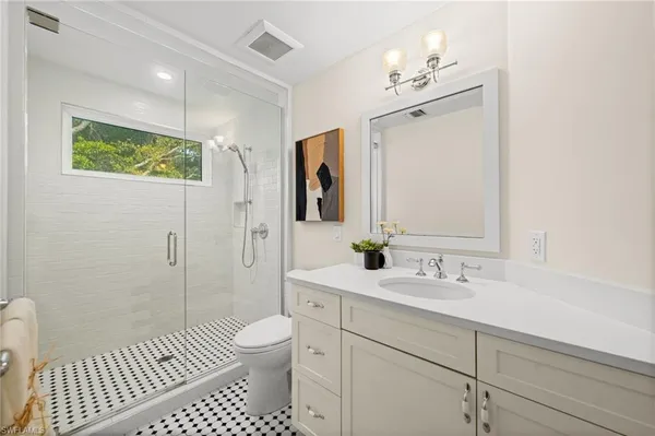 a bathroom with a sink a toilet and shower