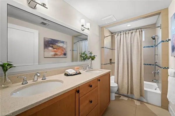 a bathroom with a granite countertop sink a mirror a vanity and shower