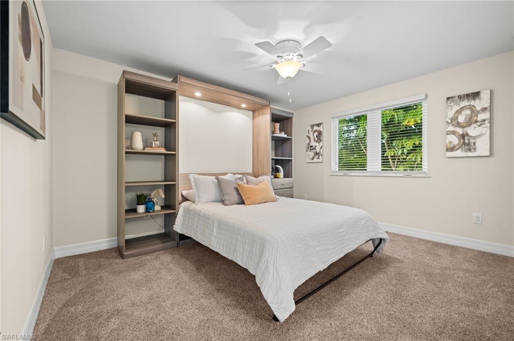 2499 10th Street North Naples, FL 34103 - Photo 26 of 33 a bed room with a bed and a chandelier