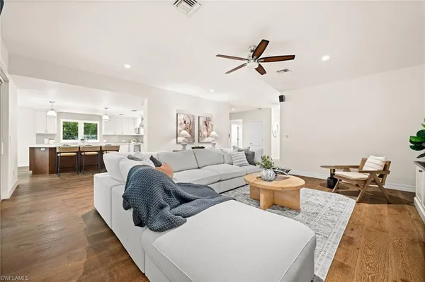 a living room with furniture and a view of kitchen
