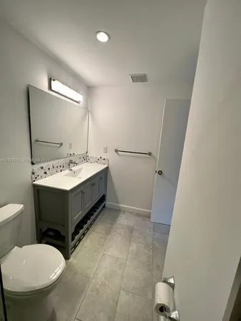 a bathroom with a sink toilet and mirror