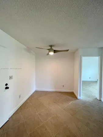 an empty room with a ceiling fan and carpet