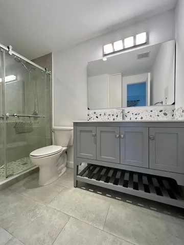 a bathroom with a double vanity sink mirror and toilet
