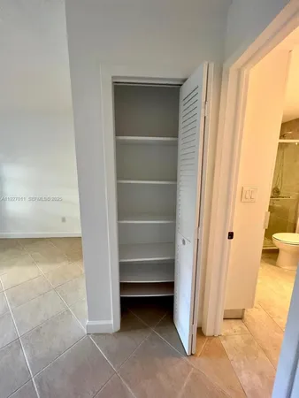 a view of walk in closet with empty racks