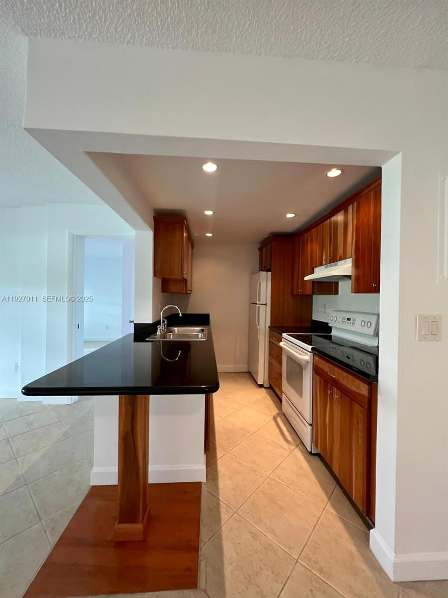 2201 Brickell Avenue, Unit 83 Miami, FL 33129 - Photo 10 of 16 a kitchen with stainless steel appliances granite countertop a sink and a refrigerator