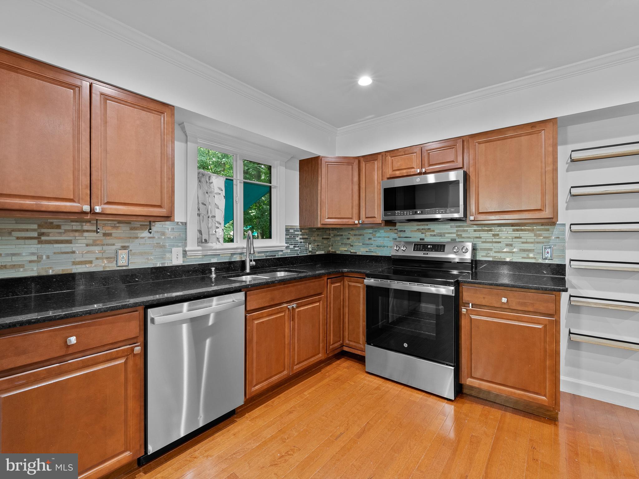 2459 Pyrenees Court Reston, VA 20191 - Photo 9 of 28 a kitchen with granite countertop a stove top oven a sink dishwasher and a microwave oven with cabinets