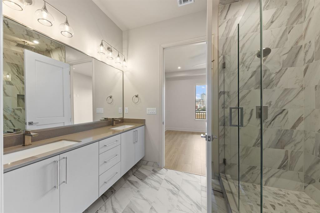 1900 South Ervay Street, Unit 508 Dallas, TX 75215 - Photo 11 of 36 a spacious bathroom with a granite countertop sink a mirror and a shower