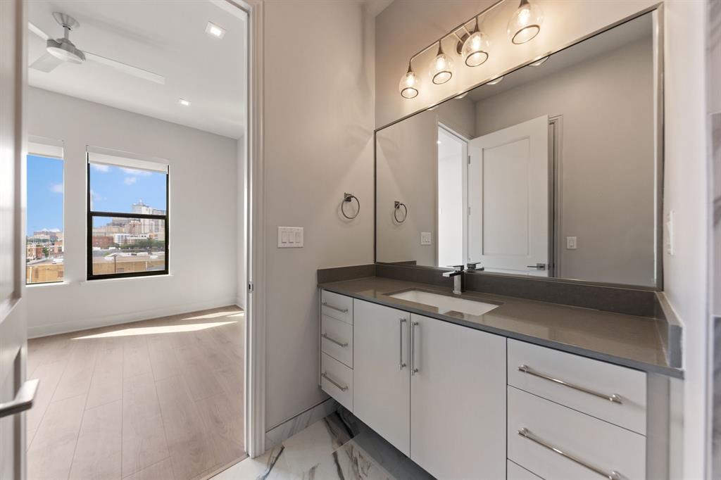 1900 South Ervay Street, Unit 508 Dallas, TX 75215 - Photo 21 of 36 a bathroom with a granite countertop sink a mirror and a