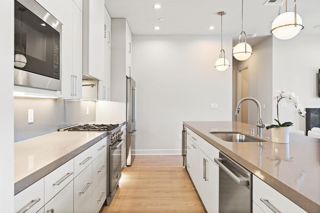 1900 South Ervay Street, Unit 508 Dallas, TX 75215 - Photo 6 of 39 a kitchen with stainless steel appliances granite countertop a sink a stove and a wooden floors
