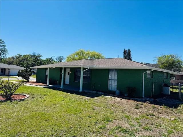 a view of a house with a yard and potted plants