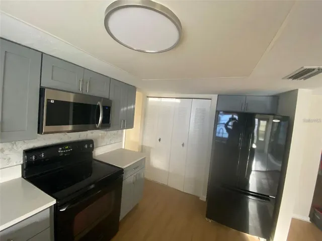 a kitchen with stainless steel appliances a refrigerator a stove a sink and a microwave