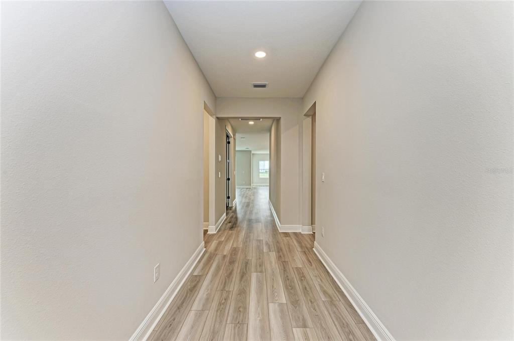 17915 Cropside Trail Lakewood Ranch, FL 34211 - Photo 12 of 33 a view of a room with wooden floor and a hallway