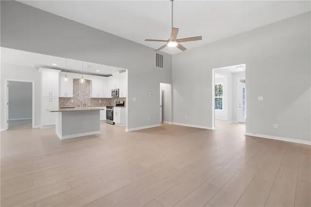 a kitchen with granite countertop white cabinets and stainless steel appliances