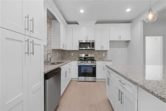 a kitchen with stainless steel appliances granite countertop a sink and a stove