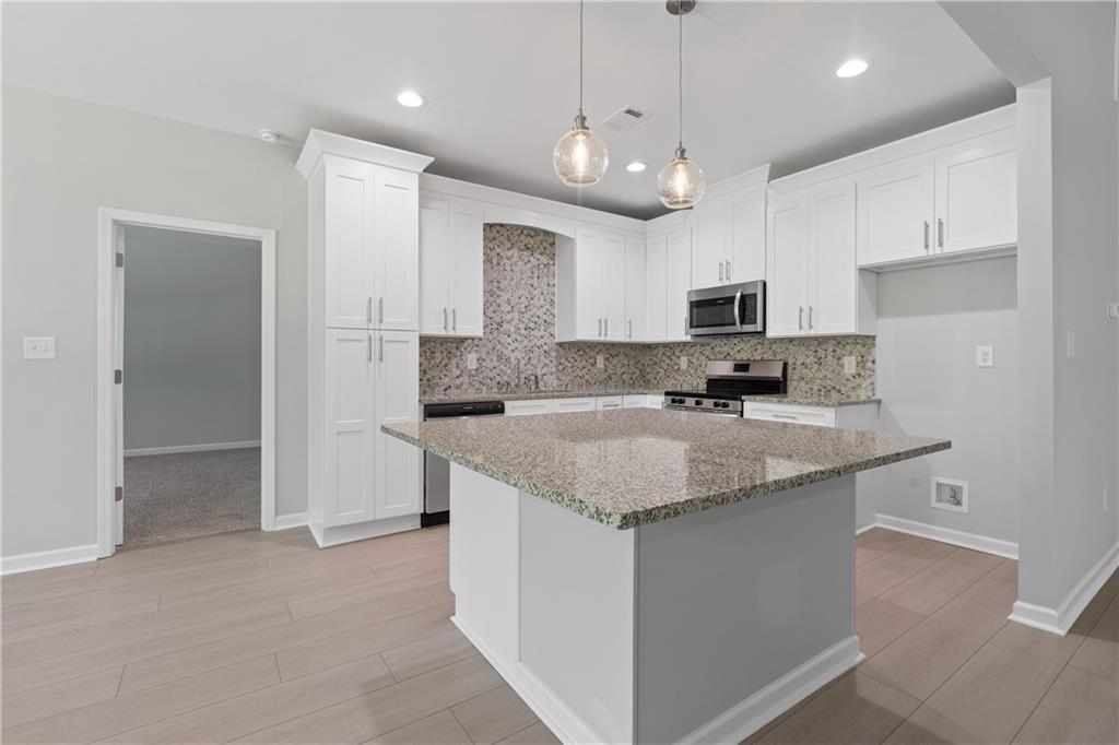 4477 Rivercliff Way Gray, GA 31032 - Photo 18 of 62 a kitchen with stainless steel appliances granite countertop a sink stove and refrigerator