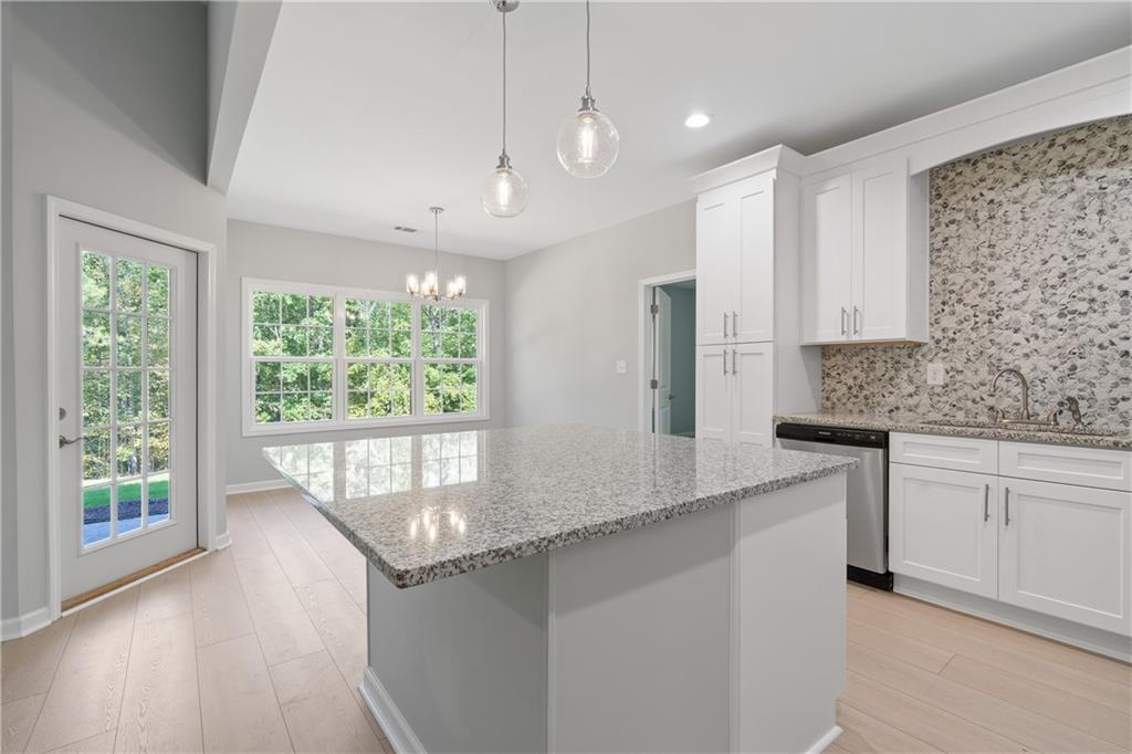 4477 Rivercliff Way Gray, GA 31032 - Photo 20 of 62 a kitchen with stainless steel appliances granite countertop a stove a sink and a granite counter tops with white cabinets