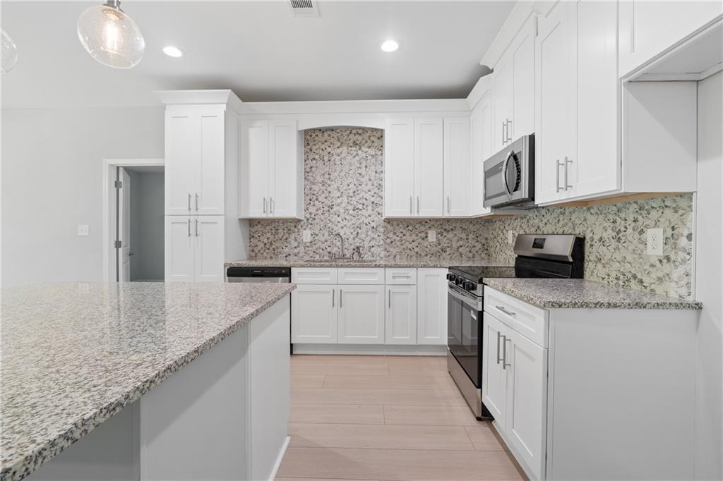 4477 Rivercliff Way Gray, GA 31032 - Photo 21 of 62 a kitchen with stainless steel appliances granite countertop a sink and a stove