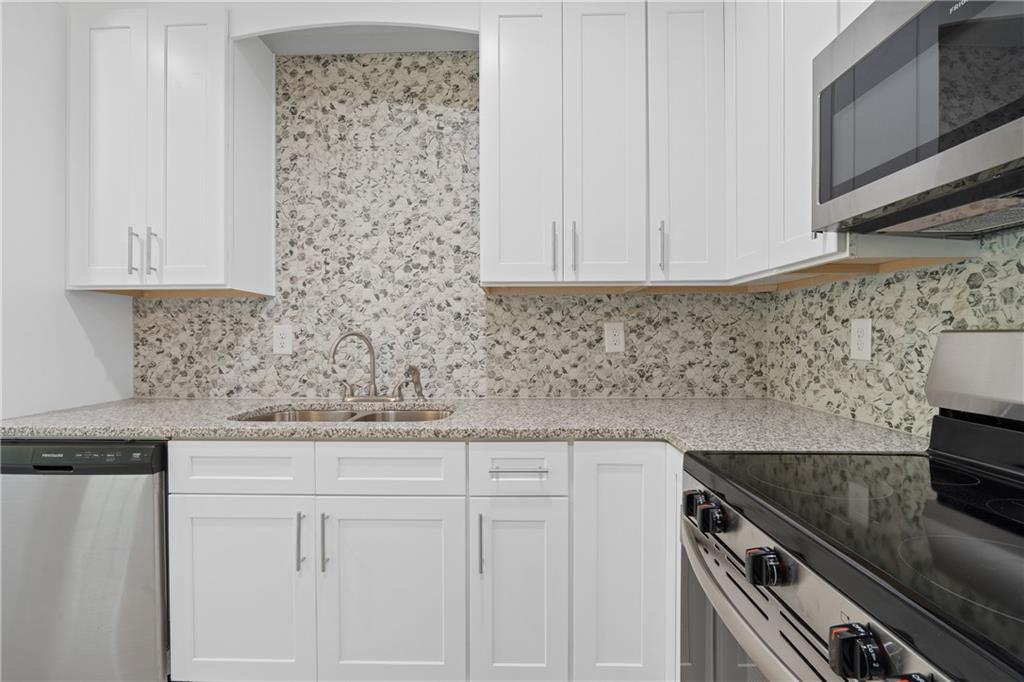 4477 Rivercliff Way Gray, GA 31032 - Photo 22 of 62 a kitchen with granite countertop white cabinets and stainless steel appliances