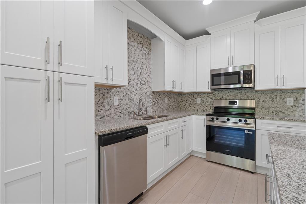 4477 Rivercliff Way Gray, GA 31032 - Photo 23 of 62 a kitchen with stainless steel appliances granite countertop a stove and a microwave
