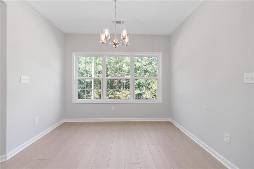 4477 Rivercliff Way Gray, GA 31032 - Photo 26 of 62 an empty room with a windows and chandelier
