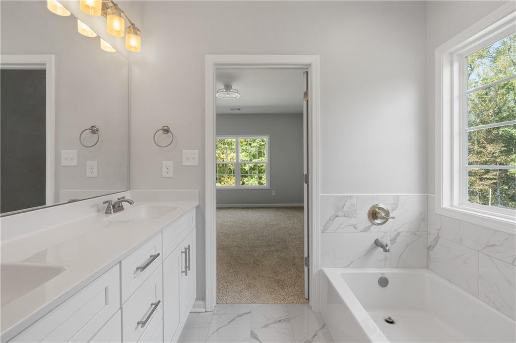 4477 Rivercliff Way Gray, GA 31032 - Photo 29 of 62 a bathroom with a tub sink and mirror