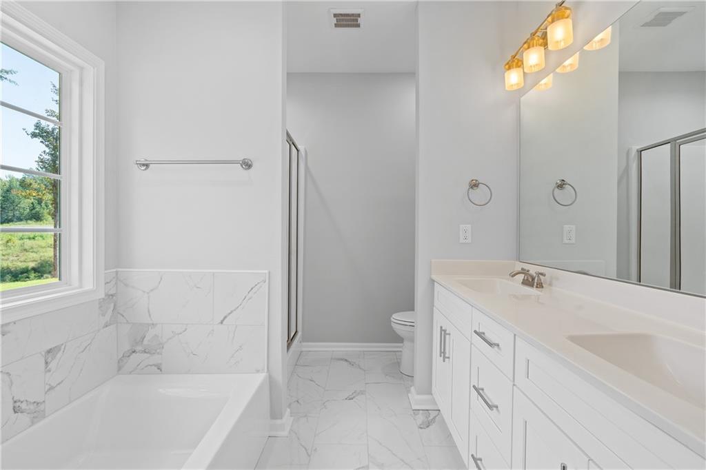 4477 Rivercliff Way Gray, GA 31032 - Photo 30 of 62 a bathroom with a tub sink and a mirror