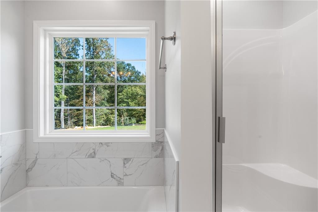 4477 Rivercliff Way Gray, GA 31032 - Photo 45 of 62 a bathroom with a bathtub and a shower