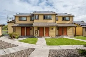 a front view of a house with a yard and trees