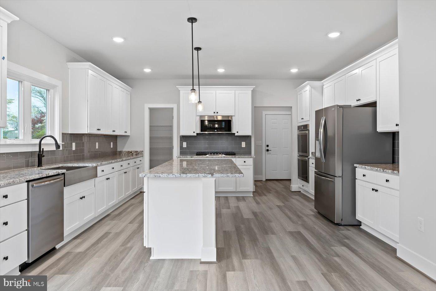575 Solgrove Road Warrenton, VA 20186 - Photo 15 of 40 a large kitchen with stainless steel appliances kitchen island a stove a refrigerator a center island a stove and a cabinets