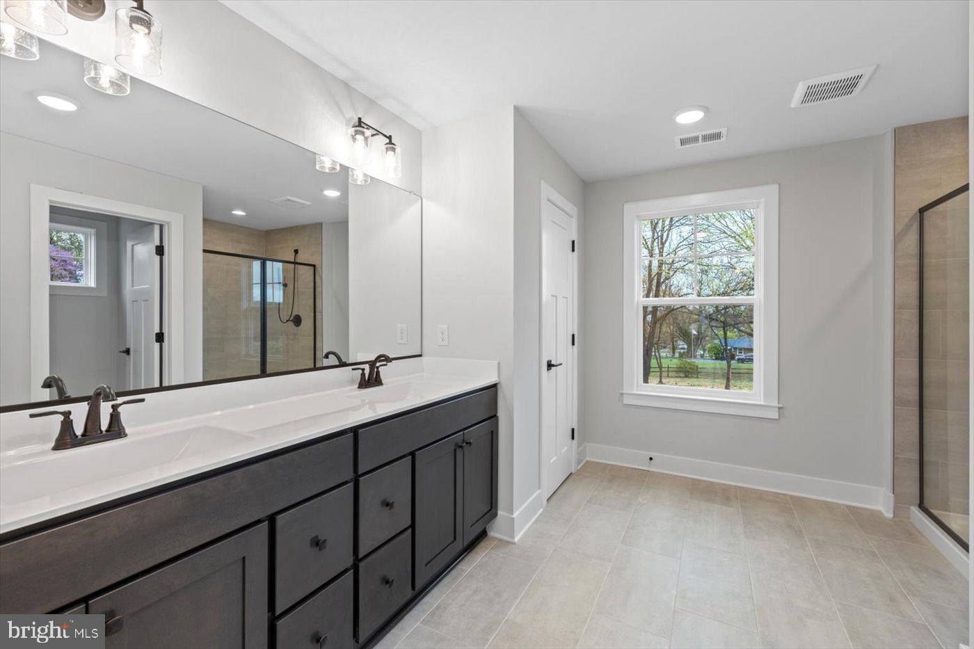 575 Solgrove Road Warrenton, VA 20186 - Photo 7 of 40 a bathroom with double vanity sinks a large mirror and a vanity