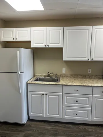 a view of a kitchen with wooden floor and electronic appliances