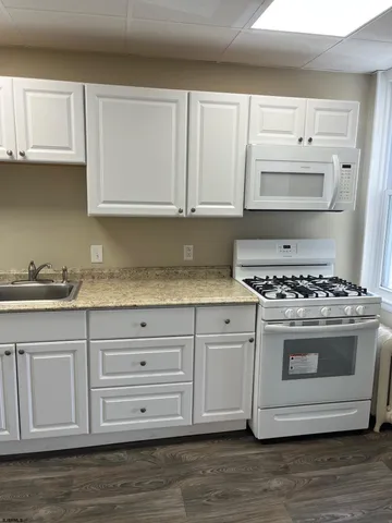 a kitchen with granite countertop a sink and a stove